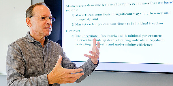 Photo of Associate Professor Ron Hayduk lecturing in front of a screen