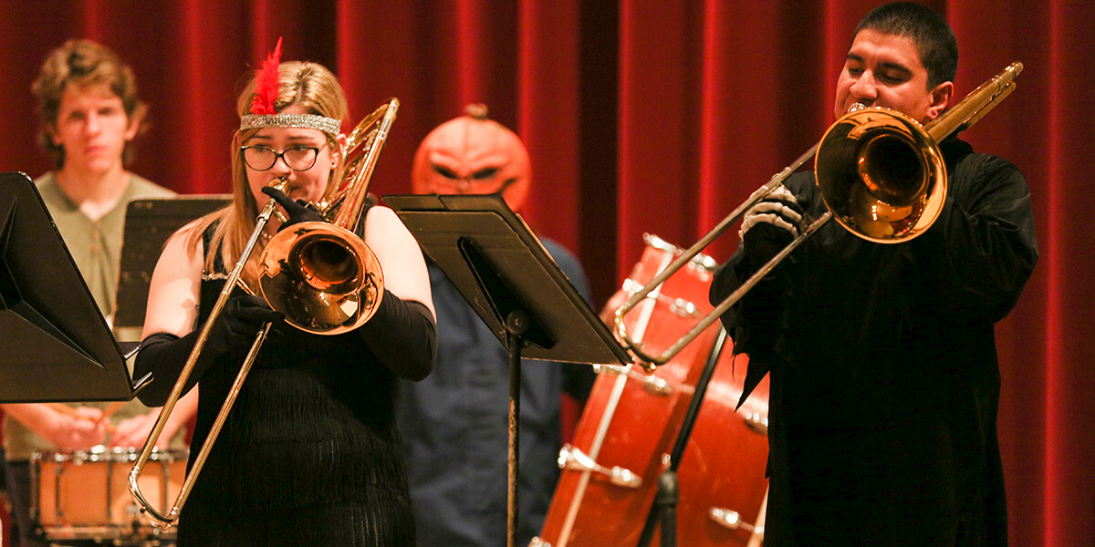 Photo of student trumpeters performing in Halloween costume