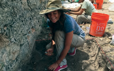 Photo of young woman participating in archaeological dig