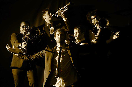 Photo of brass band Beauty Slap holding instruments