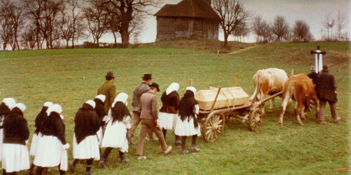 Still from The Birch Tree of carriage led by horses followed by line of people