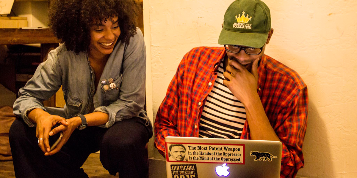 Photo of two Black Aesthetic members looking at a laptop computer