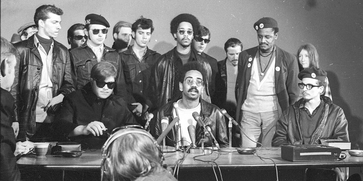 Archival black and white photo of a press conference held by the First Rainbow Coalition