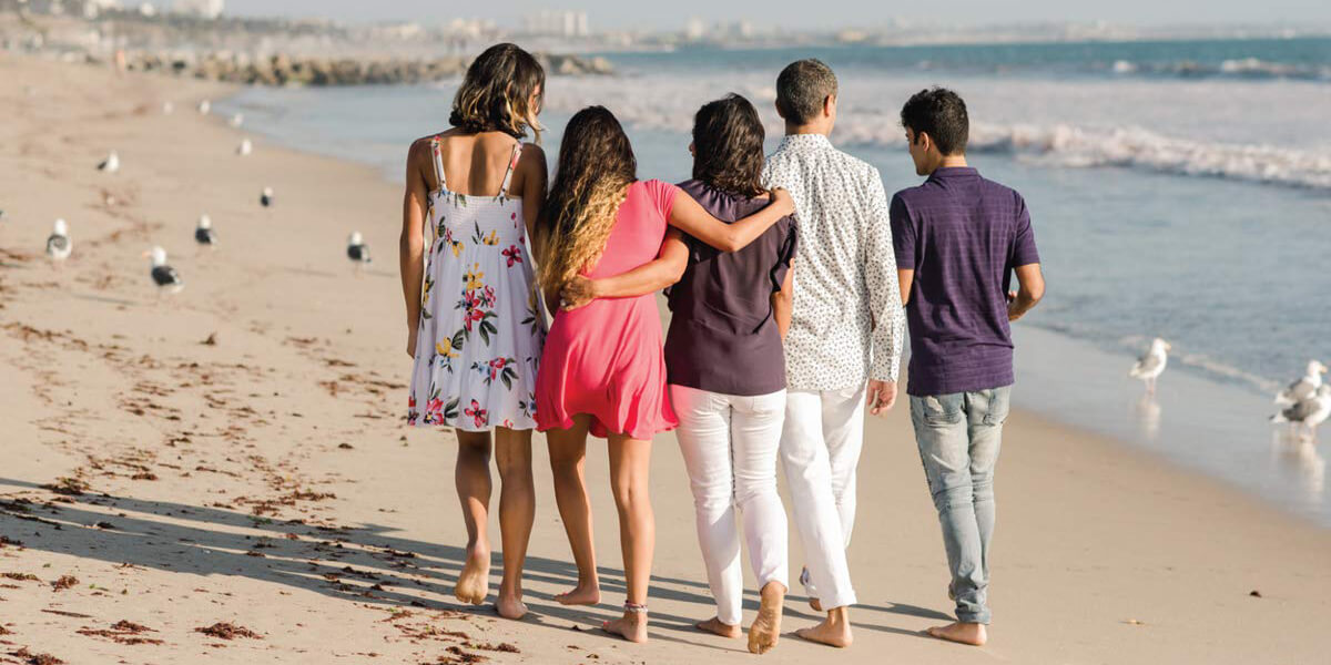 Paria Hassouri and her family walk closely together on a beach