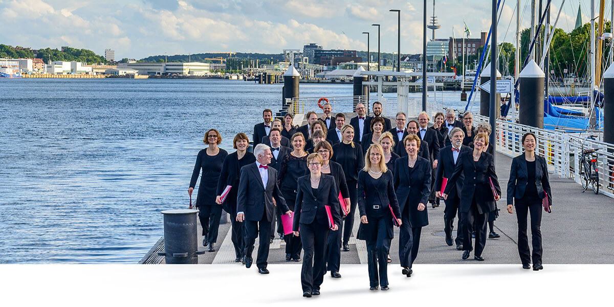 Photo of members of MadrigalChor Kiel walking on a pier
