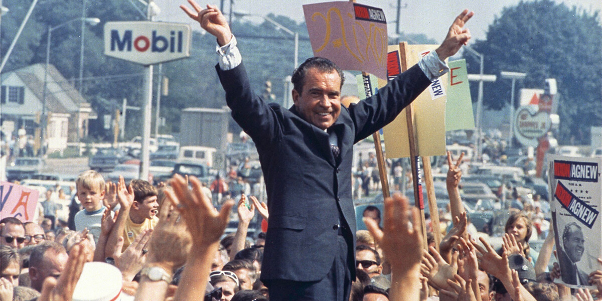 Photo of Richard Nixon flashing victory sign at 1968 rally