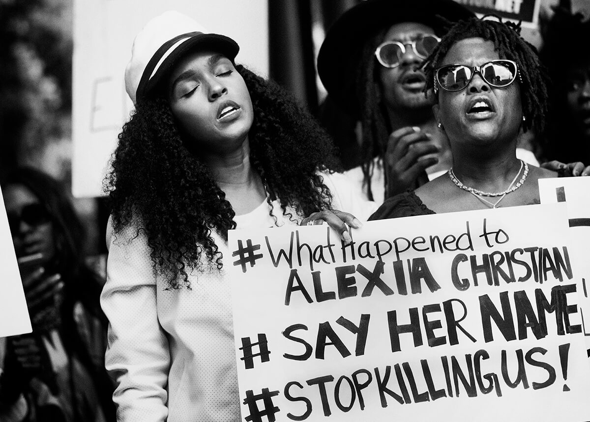 Photo of three women and sign protesting death of Alexia Christian