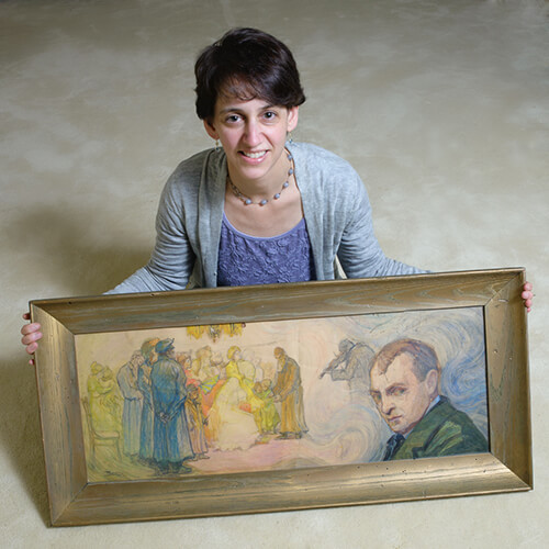 Photo of Elizabeth Rynecki holding her great-grandfather's painting