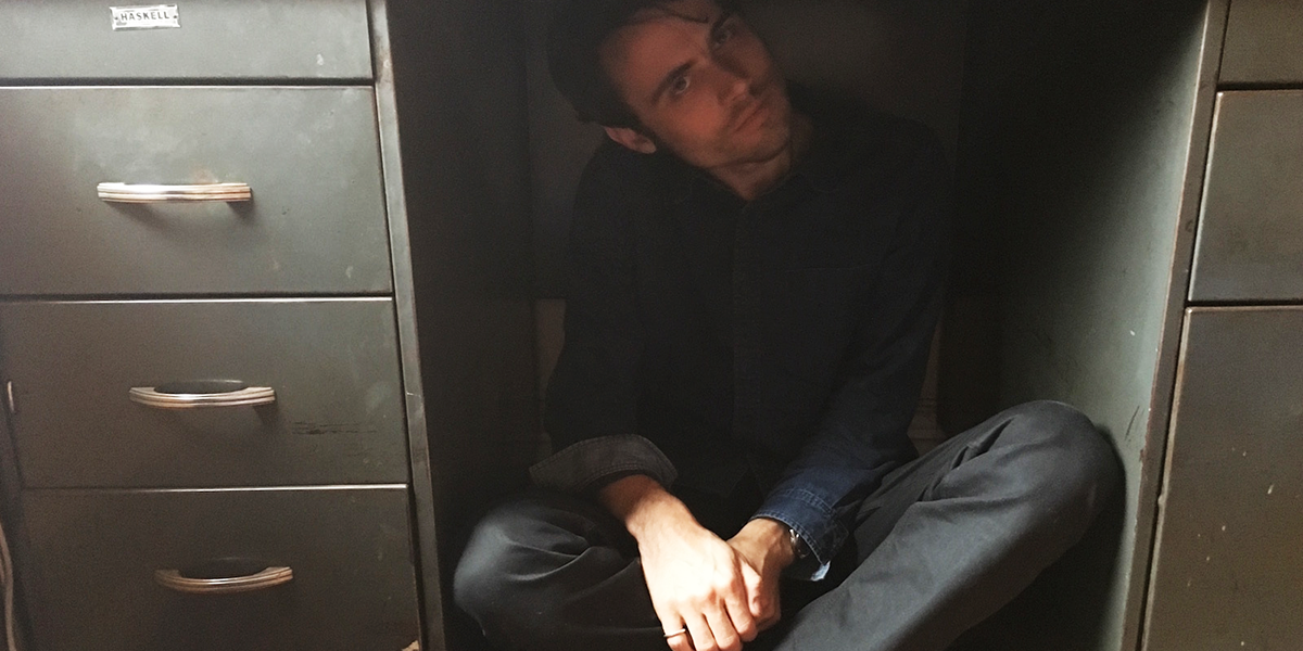 Photo of Kit Schluter sitting under a desk