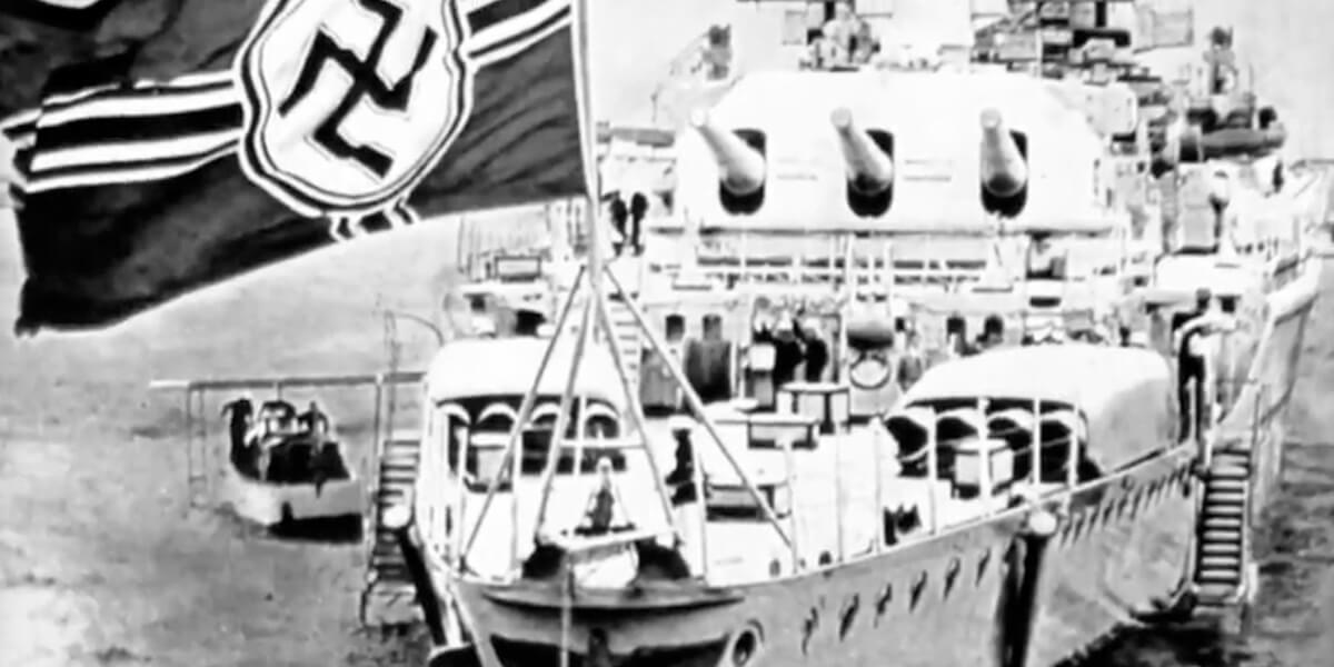 Black and white photo of military ship with large Nazi flag on its bow