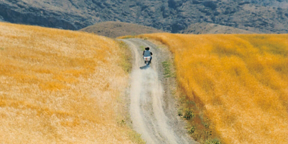 Photo of motorcycle driving on a dirt road in a rural area