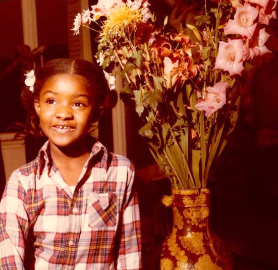 Photo of a child next to a bouquet of flowers