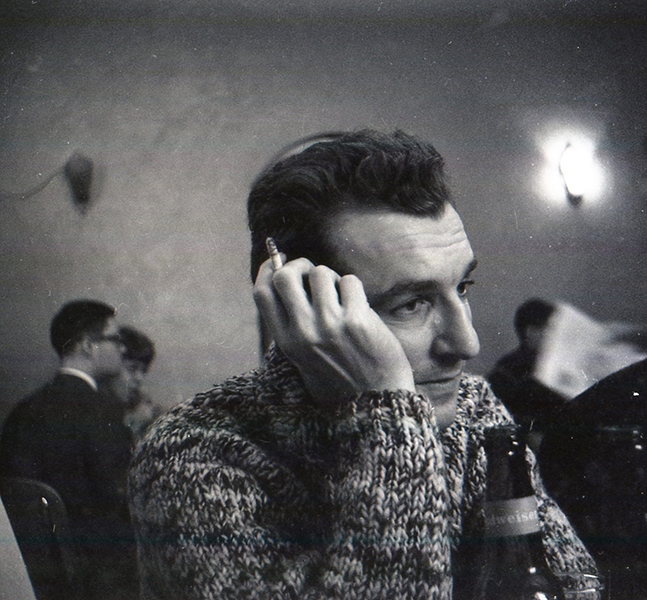 Photo of John Wieners with a beer bottle and holding a cigarette