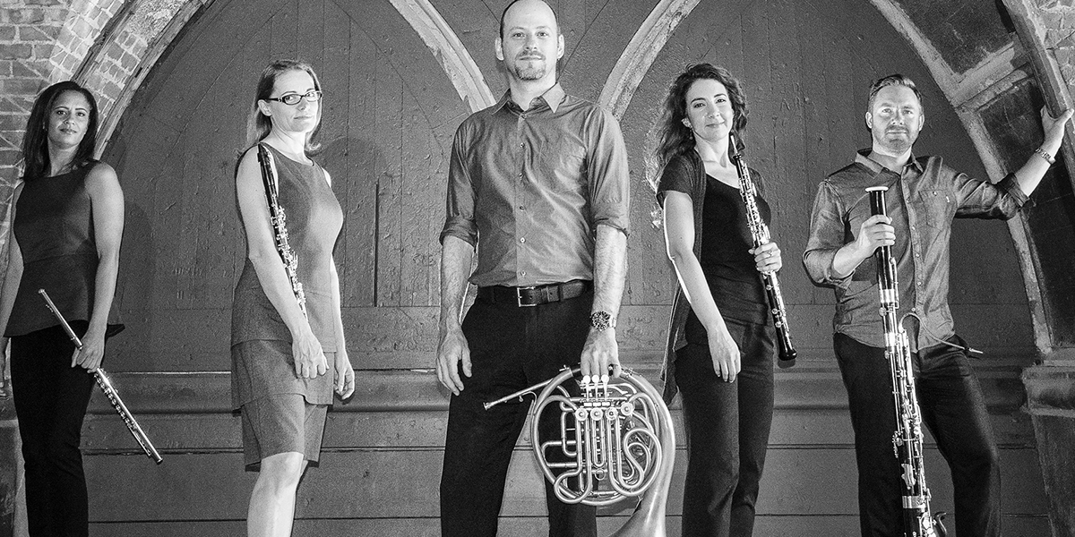 Black and white photo of Zephyros Winds quintet holding instruments