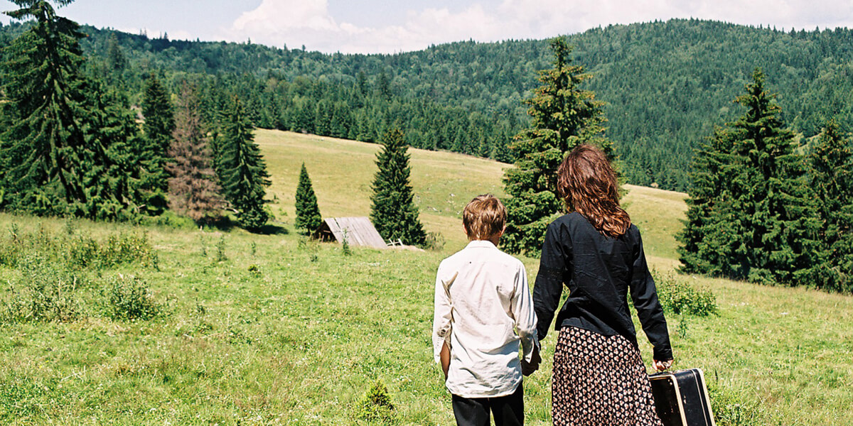 Photo of son and mother looking at view of a forest