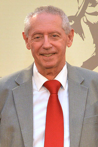 Photo of Jose Kozer wearing suit with red tie