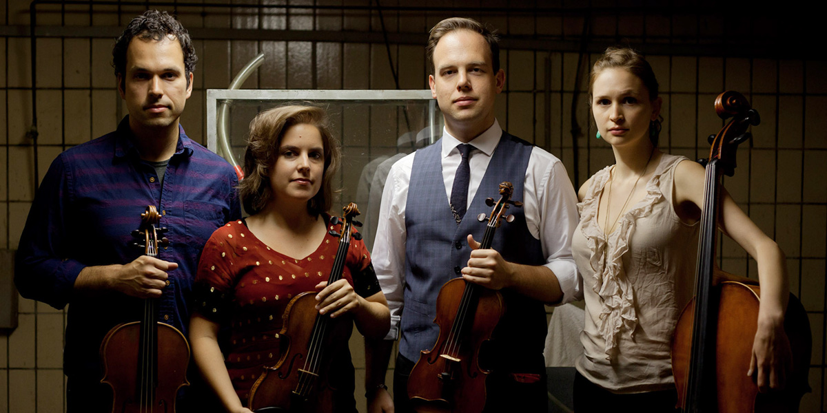 Photo of Mivos Quartet holding musical instruments