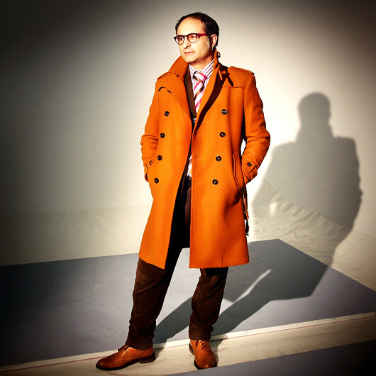 Photo of Giona Nazarro standing and wearing orange overcoat