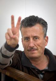 Photo of Bassem Tamimi flashing the victory sign