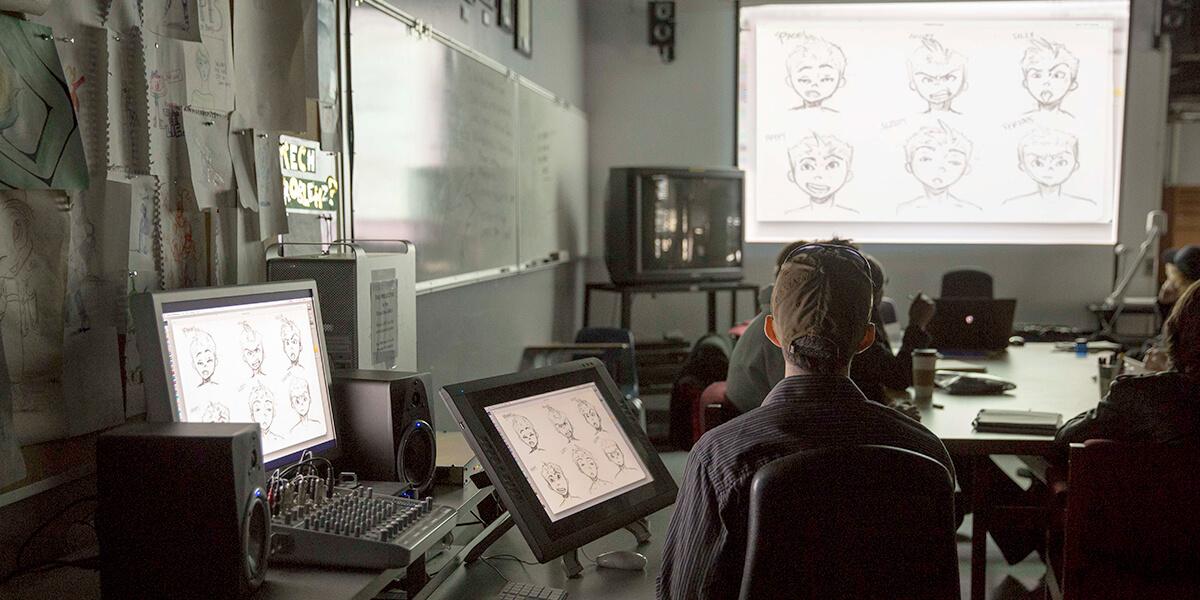Photo of animation class with drawing of faces shown on several screens