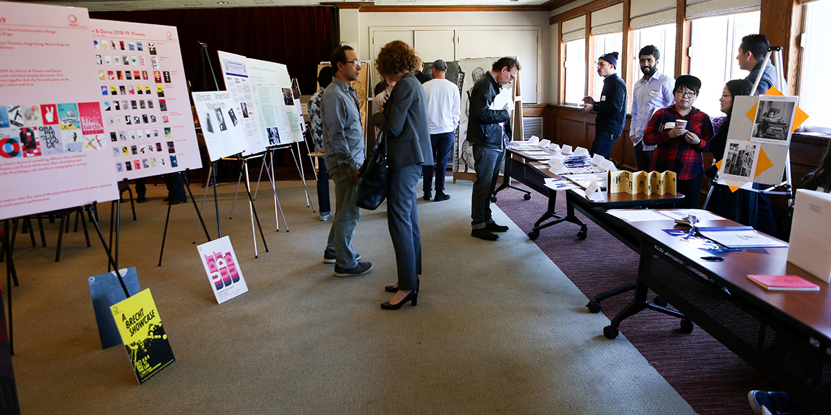 Photo of people viewing artwork and presentations