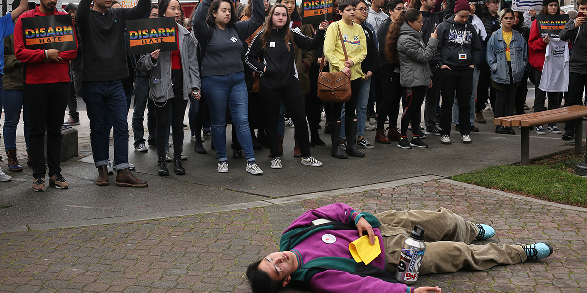 Photo of student lying on ground in front of other student protesters