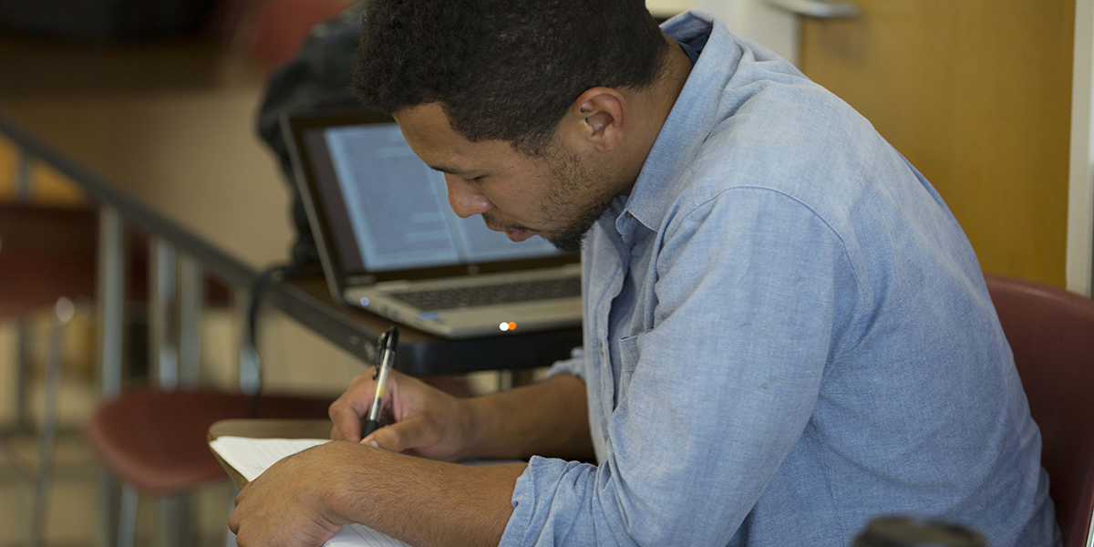 Photo of student writing at a desk