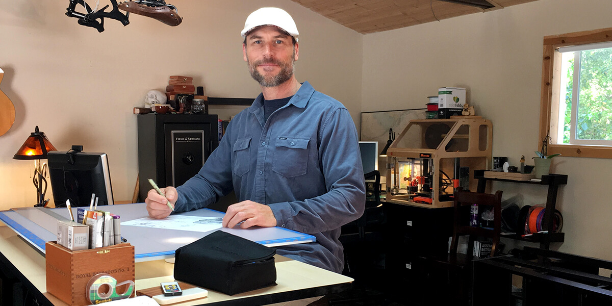 Photo of Jason Appler standing at drawing table with pencil in hand