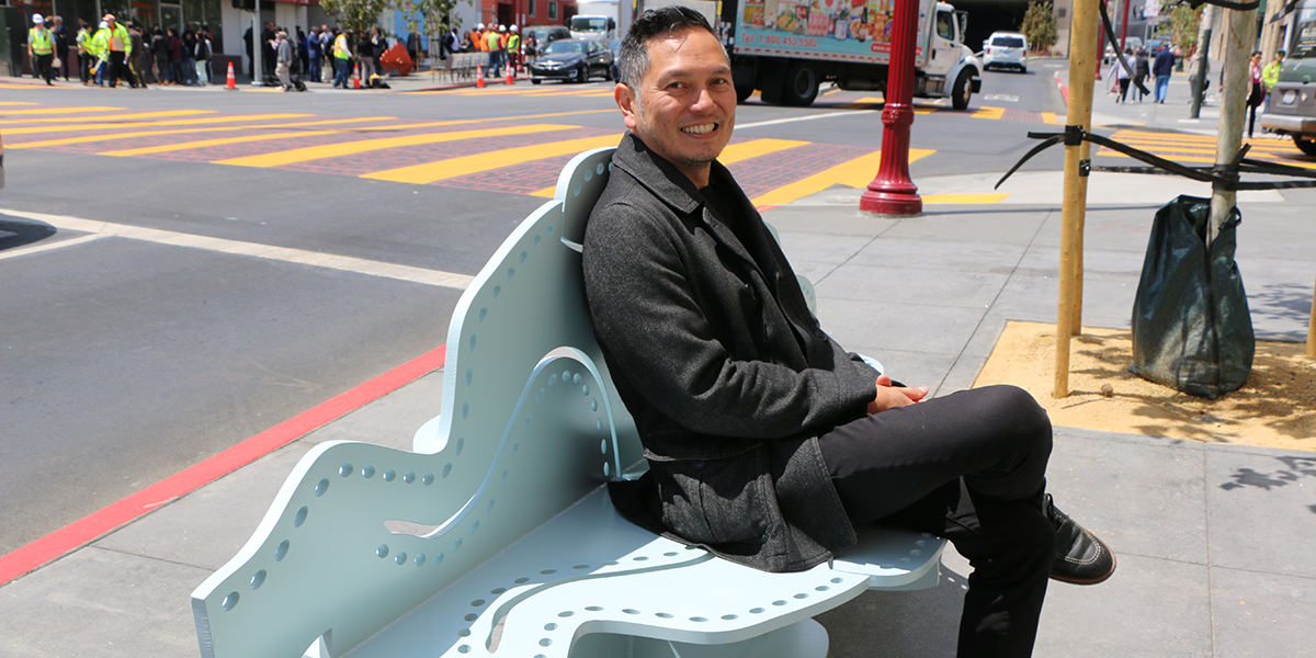 Photo of Michael Arcega sitting on his bench in San Francisco's Chinatown