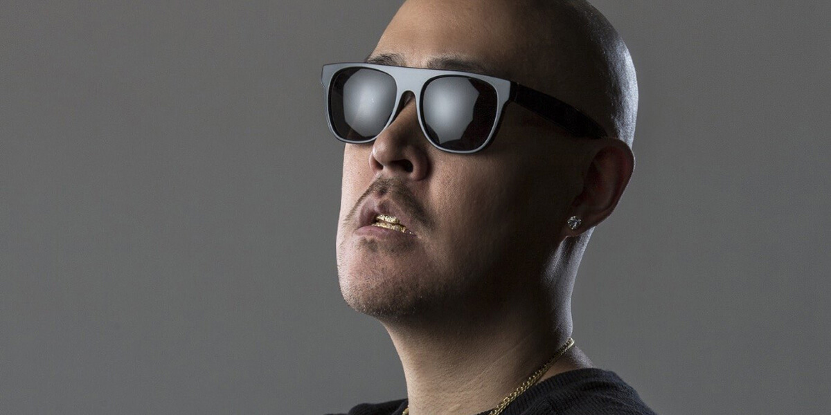 Photo of Ben Baller wearing sunglasses, earring and gold teeth