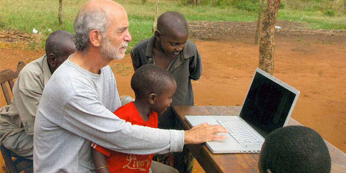 Photo of Peter Biella and children using a laptop computer