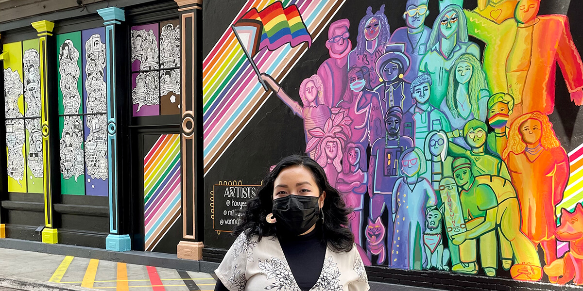 Houyee Chow standing in front of her mural in San Jose
