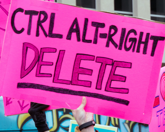 Photo of pink sign at protest that reads Ctrl Alt-Right Delete