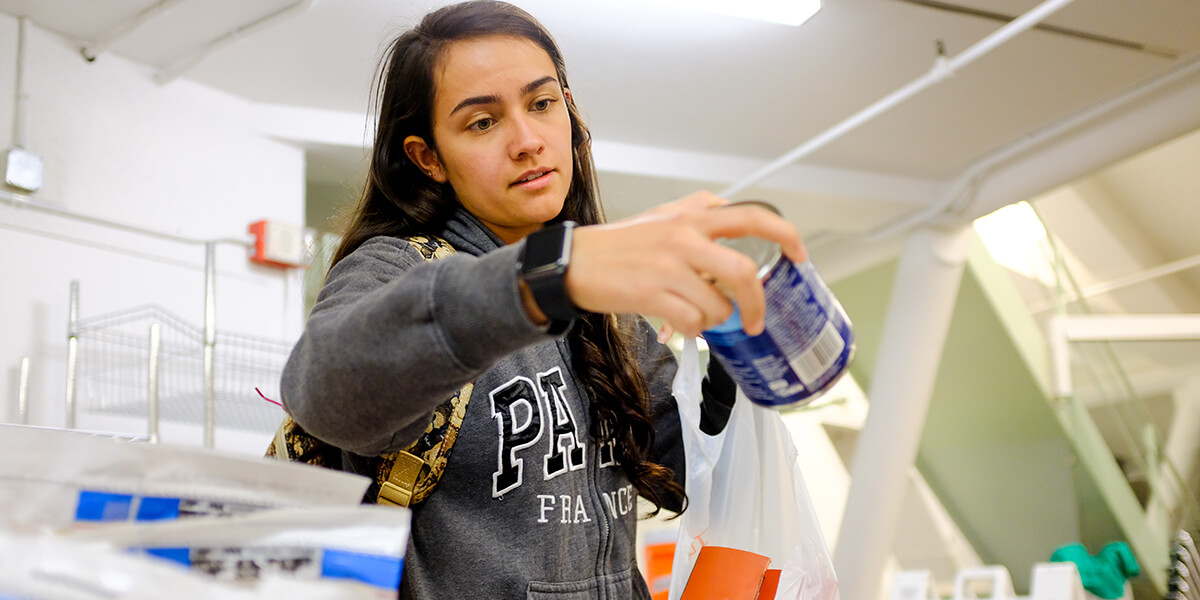 Photo of student Maria Ortega picking up a can of soup