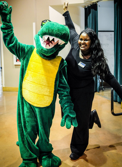 Photo of Gator mascot and a student