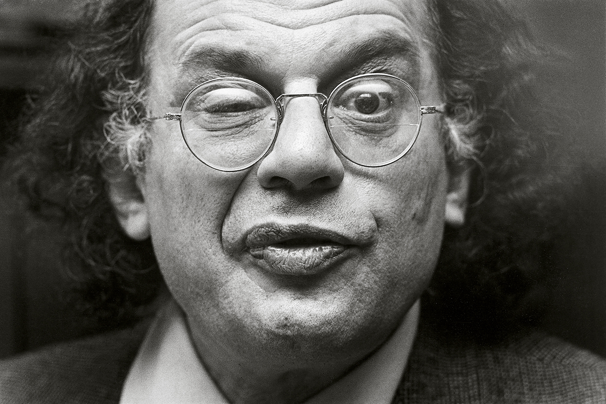 Black and white photo of Allen Ginsberg winking