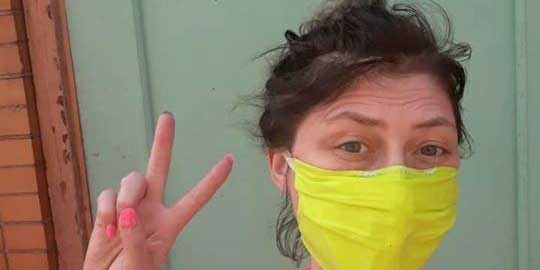 Photo of Olivia Griffin wearing a yellow mask and flashing the peace sign