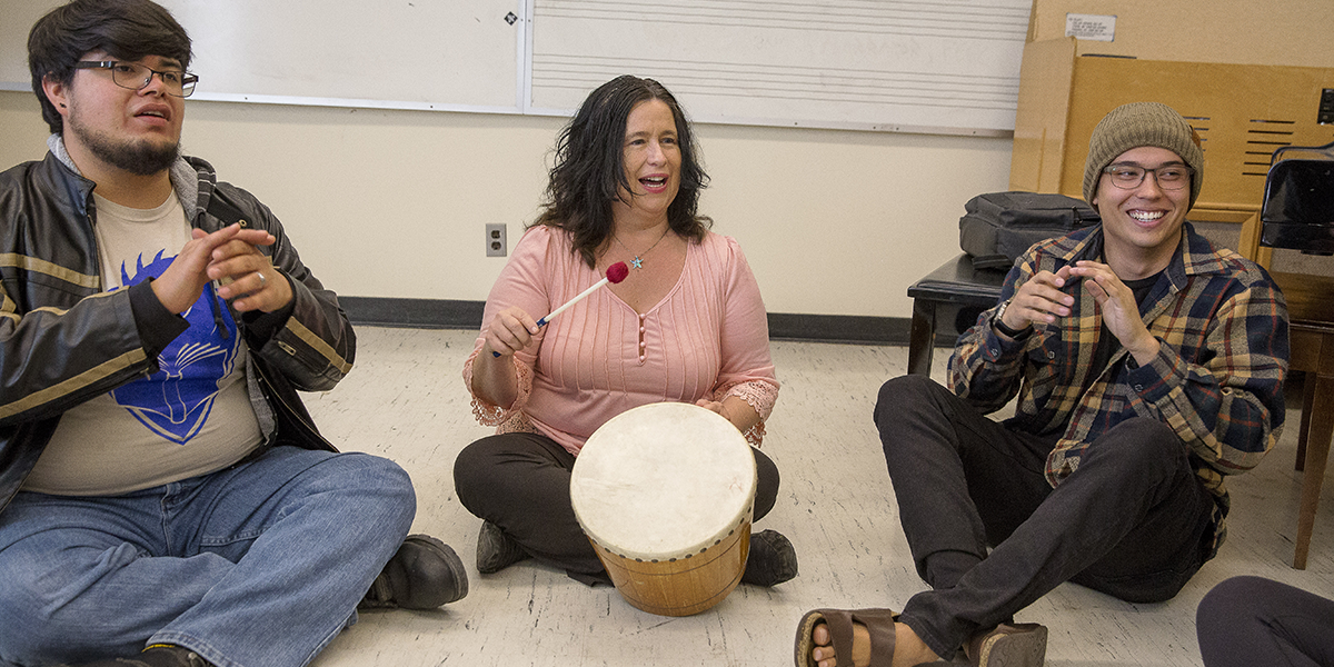 Photo of Wendell Hanna playing percussion alongside two students