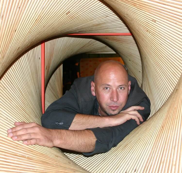 Photo of Jeff Hull crawling through a wooden contraption