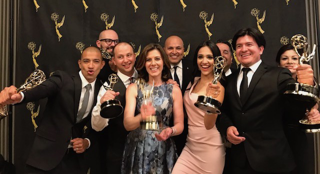Photo of KDTV staff holding Emmy Awards on red carpet