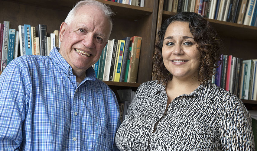 Photo of Joel Kassiola and Marcela Garcia-Castanon in front of bookshelf