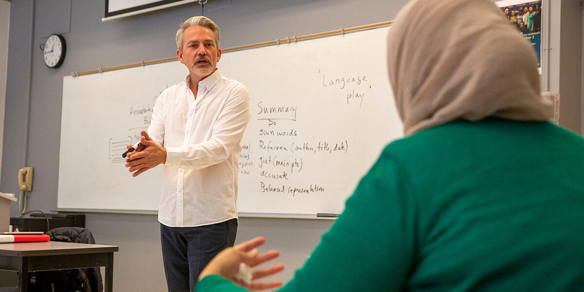 Photo of Assistant Professor Robert Kohls pressing his hands together while delivering a lecture
