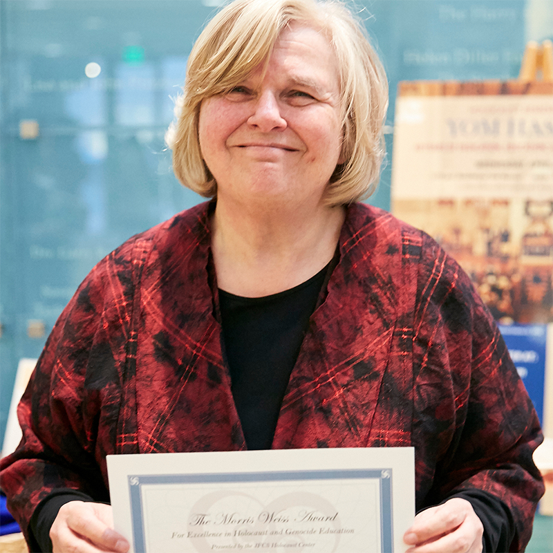 Photo of Kitty Millet holding award certificate