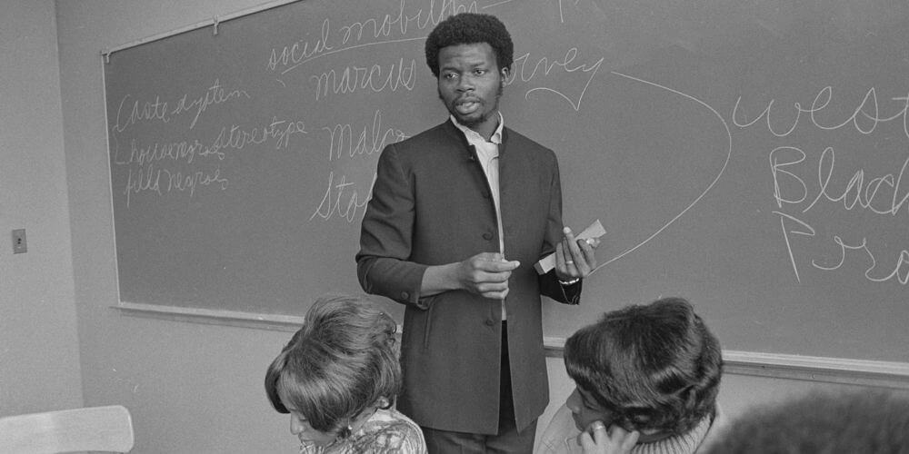 Archival black and white photo of George Mason Murray teaching a class