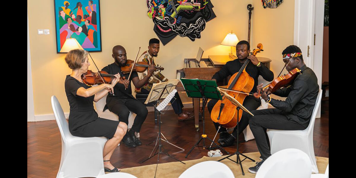 Photo of Cristina Ruotolo playing violin with three other string musicians and one pianist