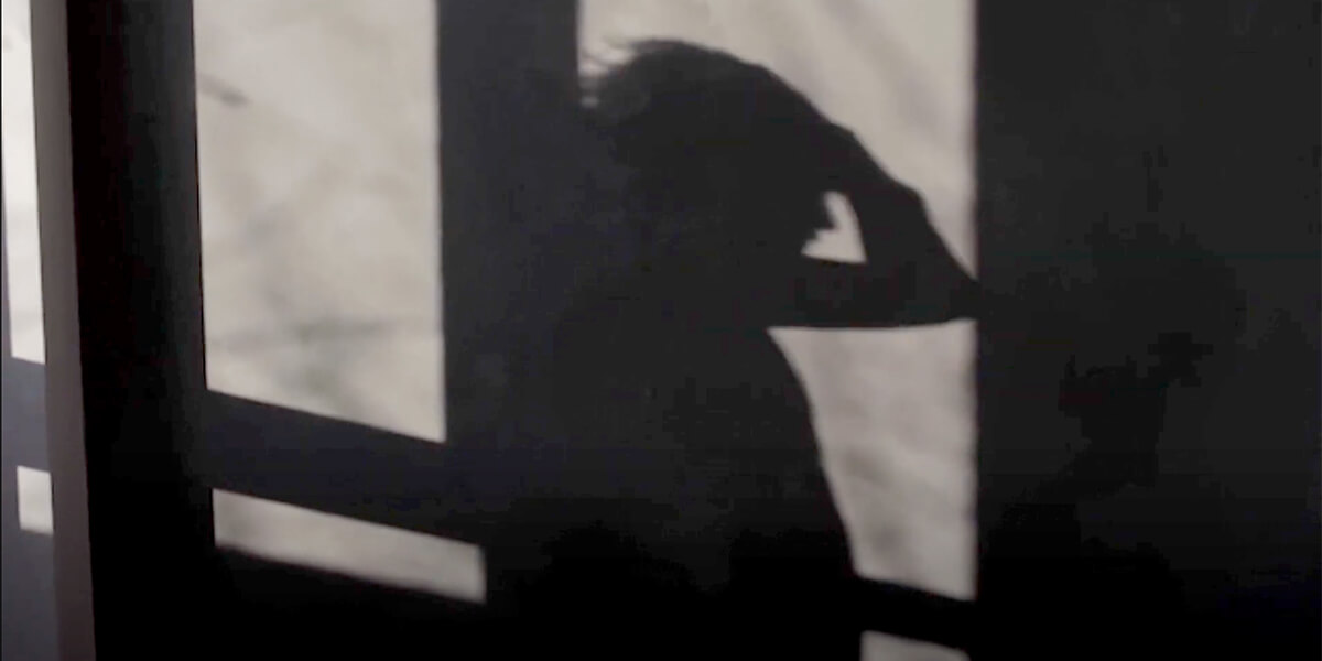 A shadow of a person touching their hair