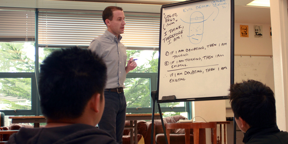 Photo of Patrick Smith teaching next to a whiteboard