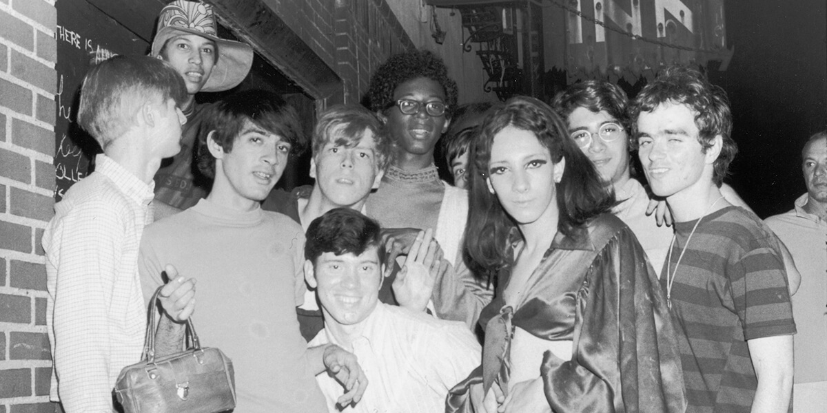 Black and white photo of 11 people standing near the Stonewall Inn in New York on June 28, 1969
