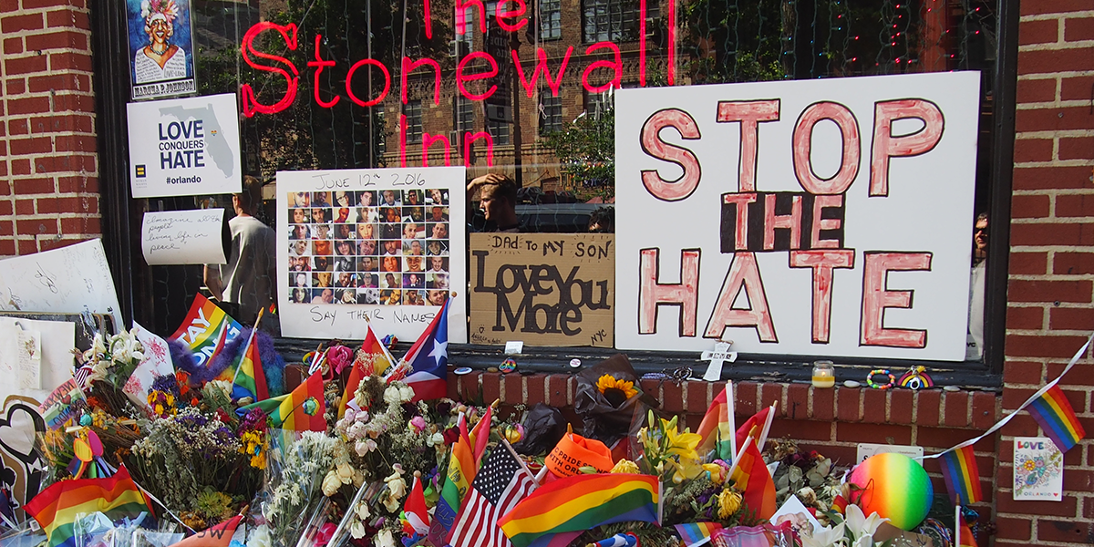 Photo of The Stonewall Inn decorated in flags and Stop the Hate sign