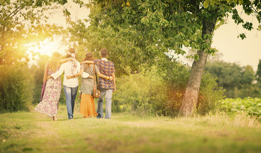 Photo of four people embracing in a wooded area